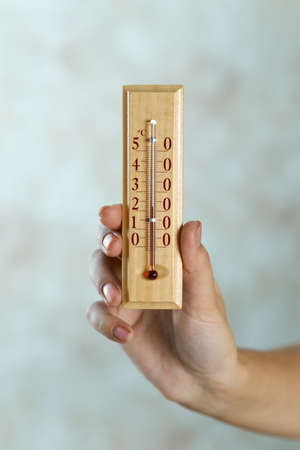 wooden thermometer in hand with Celsiusの写真素材