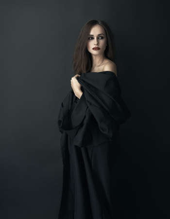 girl in a black dress on a dark backgroundの写真素材