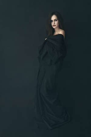 girl in a black dress in a fogの写真素材
