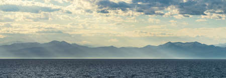 Mountains by the sea in the sunの写真素材