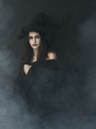 slender witch in a smoke on a black backgroundの写真素材