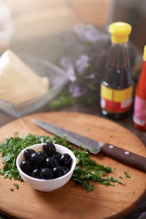 chopped parsley on a board with olivesの写真素材