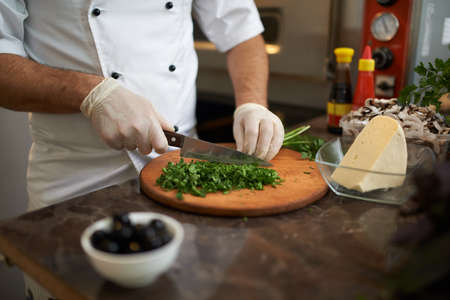 chopped green on the board with a knifeの写真素材