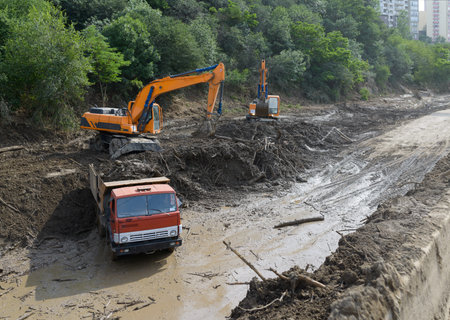 cleaning road by landslide excavator and trucks
