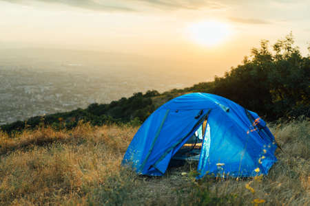 blue tent on a hill near the city in the morningの写真素材