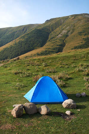 There ia a blue tent in the mountainsの写真素材