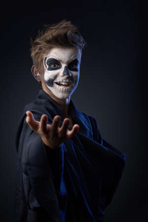 Teen with makeup skull cape showing indicatesの写真素材