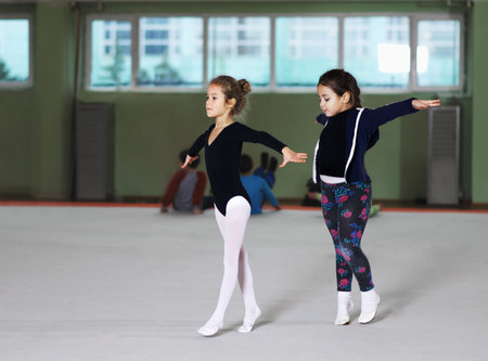 two girls practicing rhythmic gymnastics