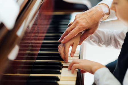 hand of an experienced pianist, music teacher helping young studentsの写真素材
