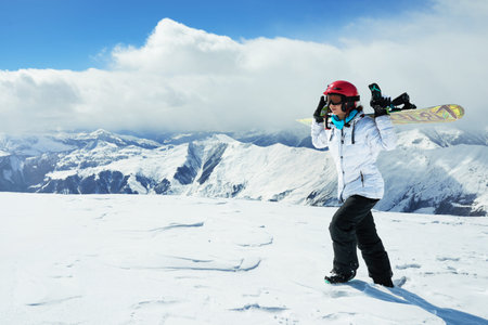 girl snowboarder is in the mountains and is a snowboard on shoulders.の写真素材