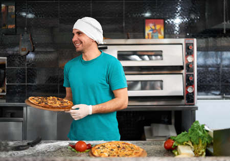 cook pizza at the table preparing a fresh pizzaの写真素材