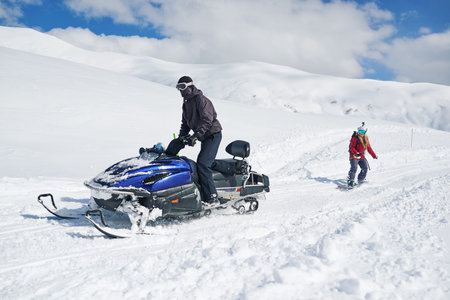 snowmobile drags in tow girl snowboarderの写真素材