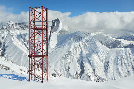 Telecommunications tower in the mountains in winter on a background of rocks and peaks.の写真素材