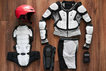 protective clothing and a helmet for the sport on a wooden floorの写真素材
