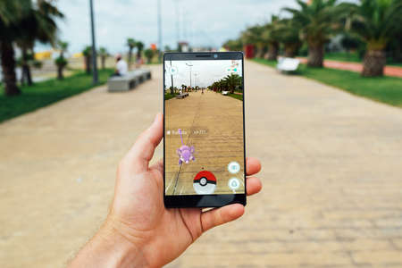 BATUMI, GEORGIA- JULY 14, 2016: Hand holding a smartphone to play the game of Augmented Reality Pokemon goのeditorial素材