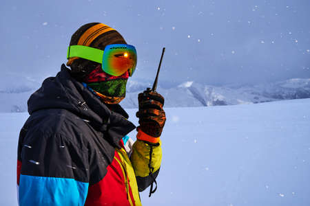 A man in a ski mask says on the radio in the background of Snowfall in the mountains.の写真素材
