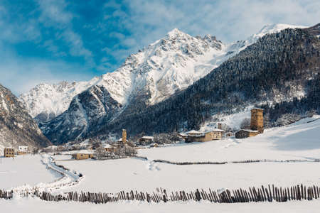 homely snow stone village with houses in the mountains near the forestの写真素材