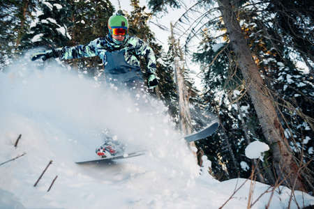 snowboarder is jumping and freeriding in the mountain forestの写真素材