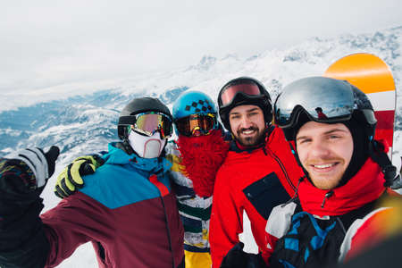 Happy snowborders is standing and making selfie on the mountainの写真素材