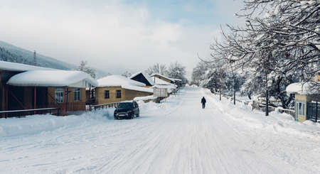 homely snow village with houses in the mountains near the forestの写真素材