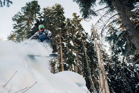 snowboarder is jumping and freeriding in the mountain forestの写真素材