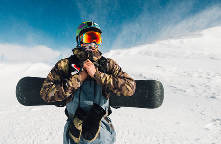 man stay with snowboard equipment on the snow hill