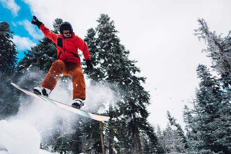 snowboarder with special equipment is riding fast, jumping, freeriding very fast in the mountain forestの写真素材