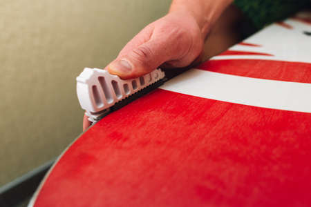 hand sharpening and waxing red snowboard very carefulの写真素材