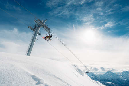 there are three man in the cabin of the cableway up to the mountainの写真素材