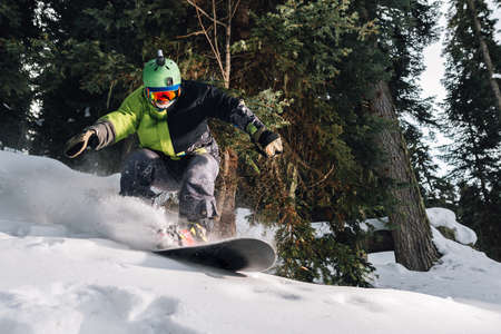 snowboarder with special equipment is riding fast, jumping, freeriding very fast in the mountain forestの写真素材