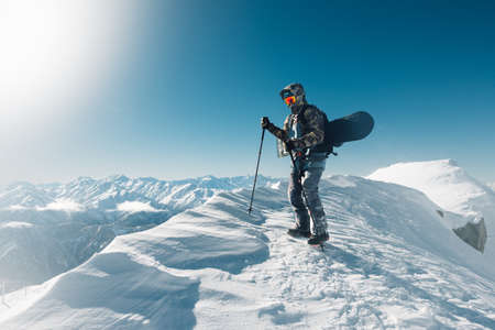 sportsman go with snowboard equipment on the snow hillの写真素材