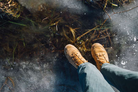 man stay on the cracked ice on the clear lake with straw under iceの写真素材