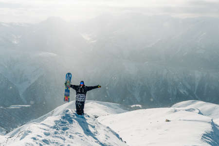 man stay and watch beautiful view with snowboard equipmentの写真素材