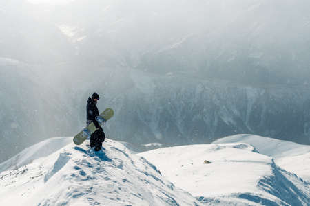 man stay and watch beautiful view with snowboard equipmentの写真素材