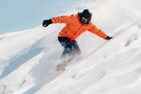 snowboarder is riding with snowboard from powder snow hillの写真素材