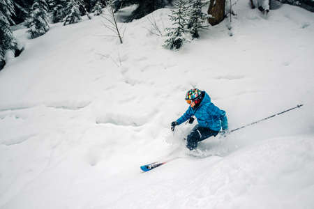 girl with special ski equipment is riding fast, jumping, freeriding very fast in the mountain forestの写真素材