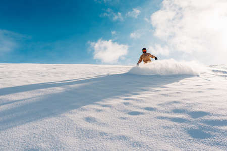 snowboarder is riding with snowboard from powder snow hillの写真素材
