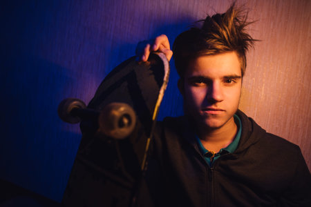 teenager in the orange-blue light with a skateboard