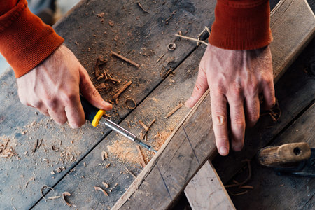 tightening the screw with a screwdriver in a wooden block, making furniture