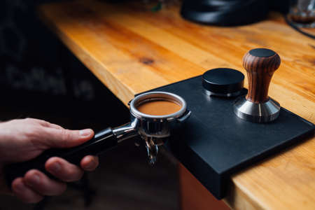 tempered coffee in portafilter on a dark background, close-upの写真素材
