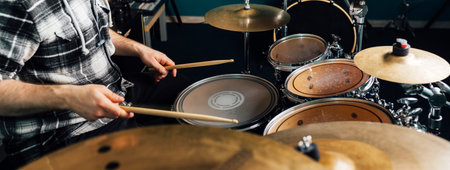The drummer knocks on the drum set.