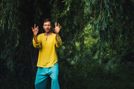 A man does hands exercises. Qigong practice in the nature.の写真素材