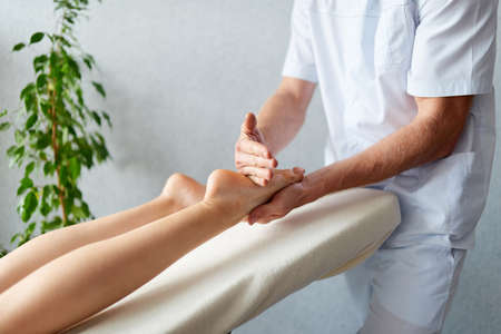 Massage therapy at the medical center. Masseur making woman foot massage.の写真素材