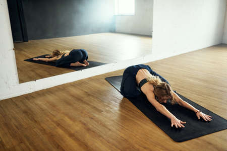 The yogi woman do childs pose. Yoga practice in the studio.の写真素材