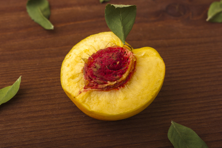Nectarine. Half a kostachkoy. On a dark wooden backgroundの写真素材