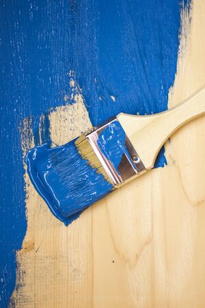 Brush in blue paint. On a painted boardの写真素材