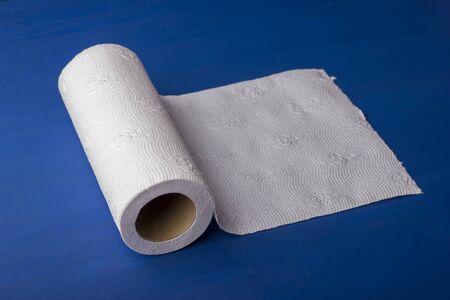 Roll of paper towel on a blue, wooden background. Kitchen towelの写真素材