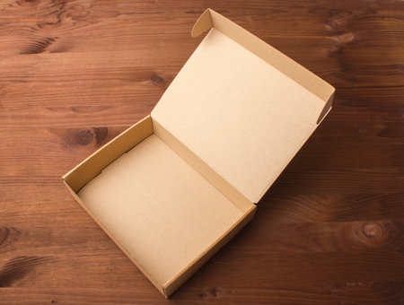 Cardboard box on a dark, wooden background. Corrugated cardboard