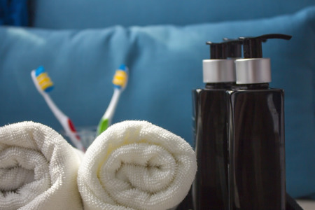White cotton towel with cosmetic products. A piece of beauty salon or bathroom interior. Copy space. Close-up の写真素材