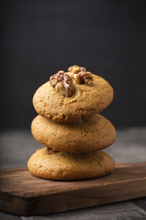 Honey biscuits with walnuts on a wooden board. Dark background. homemade food 1の写真素材